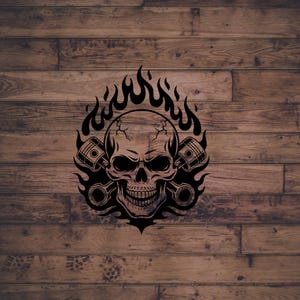 Puede incluir: Gráfico negro de una calavera con llamas y pistones. La calavera tiene dientes y grietas visibles. Las llamas rodean la calavera, y dos pistones están a cada lado. El fondo es una superficie de madera.