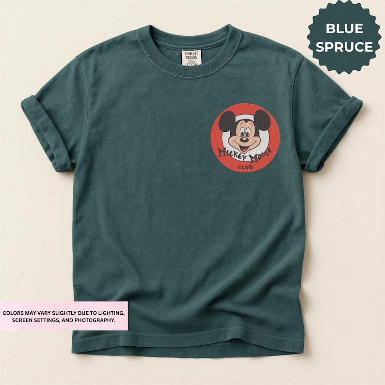 A green t-shirt with a Mickey Mouse logo and text on the front pocket.