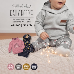 Könnte beinhalten: Ein Schnittmuster für einen Daily Hoodie mit der Aufschrift Schleiferwerk Daily Hoodie 62-146 DE+EN. Das Bild zeigt ein Kind in einem grauen Waffelstrick-Hoodie sowie einen rosa Hoodie mit Regenbogen-Motiv und einen dunkelblauen Weltraum-Hoodie.