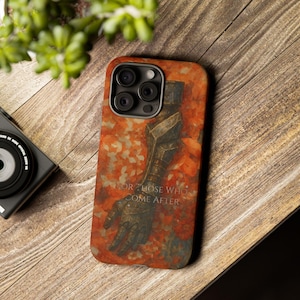May include: A phone case with a design featuring a stylized arm and the text "FOR THOSE WHO COME AFTER" in white. The case has a reddish-orange background with a floral pattern.
