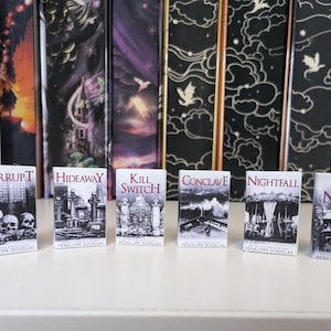 May include: A set of six miniature books by Penelope Douglas, including titles Corrupt, Hideaway, Kill Switch, Conclave, Nightfall, and Fire Night. Each small book features a black and white cover illustration with distinct gothic imagery.