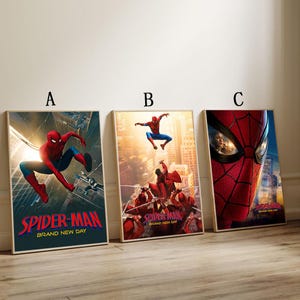 May include: Three framed Spider-Man movie posters. Poster A shows Spider-Man in a dynamic pose with the text "SPIDER-MAN BRAND NEW DAY". Poster B features Spider-Man in mid-air with the same text. Poster C is a close-up of Spider-Man's mask.