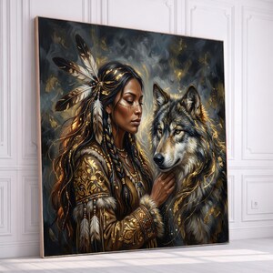 May include: A framed artwork depicts a woman with long dark hair adorned with feathers and gold accents, alongside a wolf. The woman wears a detailed, ornate garment with gold patterns. The artwork has a dark, textured background.