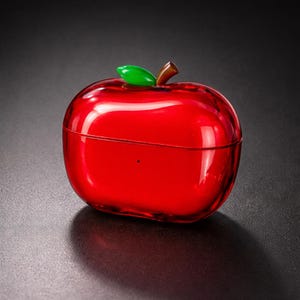 May include: A vibrant red apple-shaped case, complete with a green leaf and a brown stem. The case has a glossy finish and is set against a dark background. A fun, fruit-inspired design.
