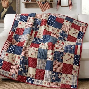 May include: A patchwork quilt draped over a white sofa, featuring a patriotic design. The quilt incorporates red, white, and blue squares with star and stripe patterns, along with floral and plaid fabrics. The room is decorated with American flags and a portrait.