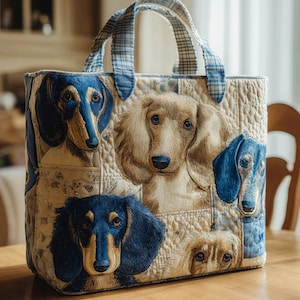 Può includere: Borsa tote trapuntata con ritratti dettagliati di bassotti nei toni del blu e beige. La borsa ha uno sfondo color crema con un motivo trapuntato e manici a quadri blu.
