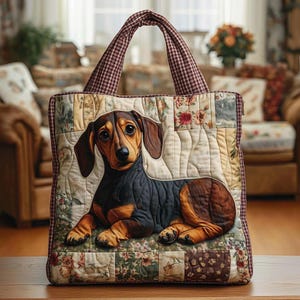 Pode incluir: Uma sacola tote acolchoada com um design de cachorro dachshund. A sacola tem um padrão de patchwork com estampas florais e geométricas em tons de creme, marrom e bordô. As alças têm um padrão xadrez vermelho e branco.