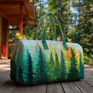 Puede incluir: Una bolsa de viaje acolchada con un diseño de bosque, que muestra árboles verdes, amarillos y naranjas. Tiene dos asas verdes y un cierre de cremallera. La bolsa está sobre una superficie de madera.