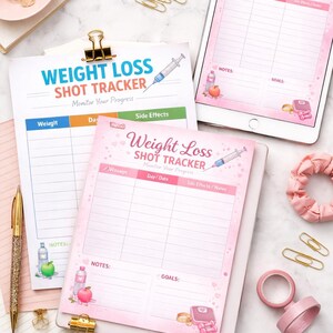 以下が含まれることがあります： ピンクと白の体重減少ショットトラッカーパッドとタブレットのコレクション。パッドには、体重、日付、副作用のセクションがあり、注射器、リンゴ、ウォーターボトルのイラストが描かれています。ゴールドのペーパークリップとペンも表示されています。