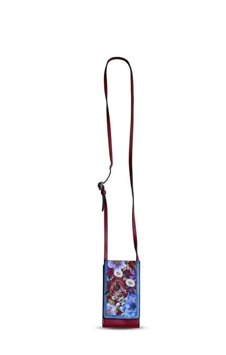 May include: A rectangular crossbody bag with a floral design. The bag features a red leather base and strap, with a colorful floral print on the front. The strap is long and adjustable. The flowers are in shades of red, purple, blue, and white.