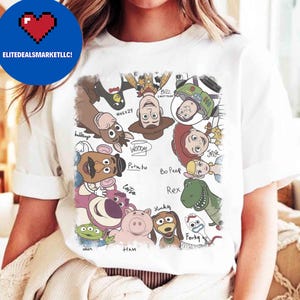 May include: White t-shirt featuring a colorful graphic of various Toy Story characters, including Woody, Buzz Lightyear, and Rex. The design includes character names and is centered on the shirt. The shirt is made of a soft material.