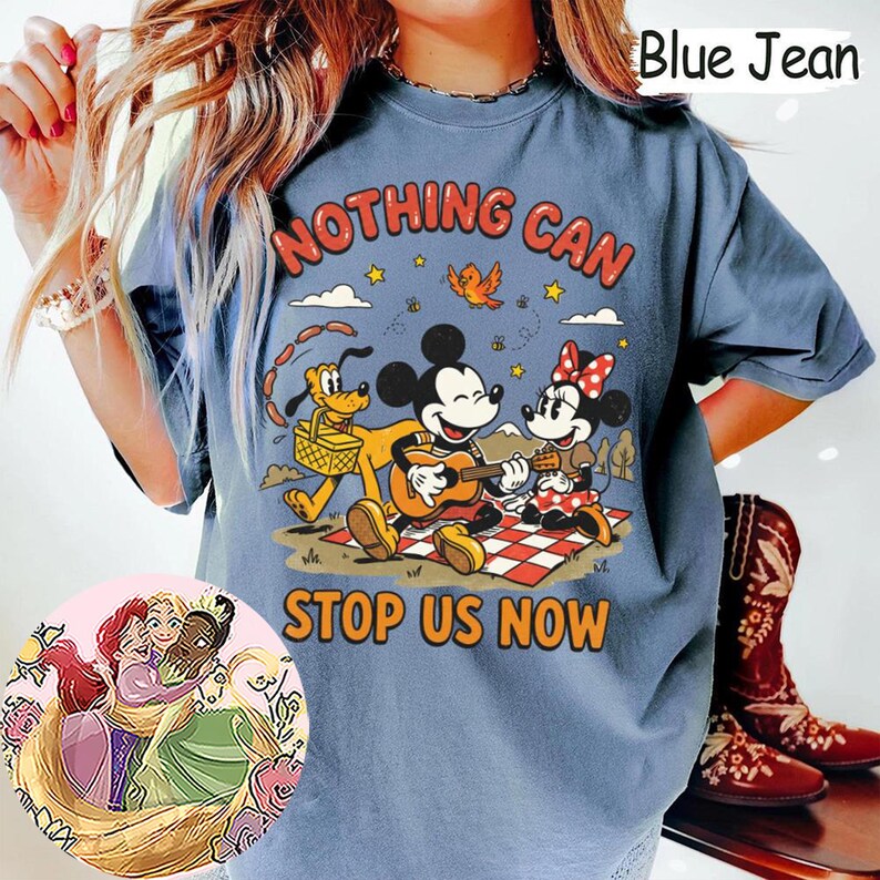 May include: A blue jean colored t-shirt featuring a graphic of Mickey Mouse playing a guitar, Minnie Mouse, and Pluto on a picnic blanket. The text reads NOTHING CAN STOP US NOW. A circular inset shows an illustration of three animated characters.