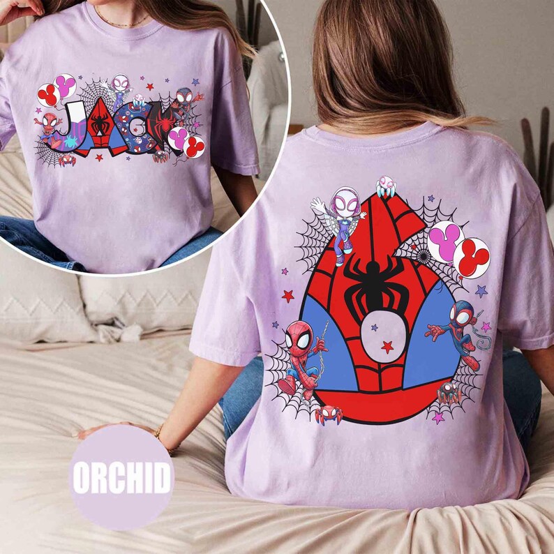 Puede incluir: Camiseta color orqu&iacute;dea con un gr&aacute;fico colorido del nombre "JACK" e ilustraciones de Spider-Man. La parte trasera muestra un gran emblema de Spider-Man con dise&ntilde;os de personajes y detalles de telara&ntilde;as.