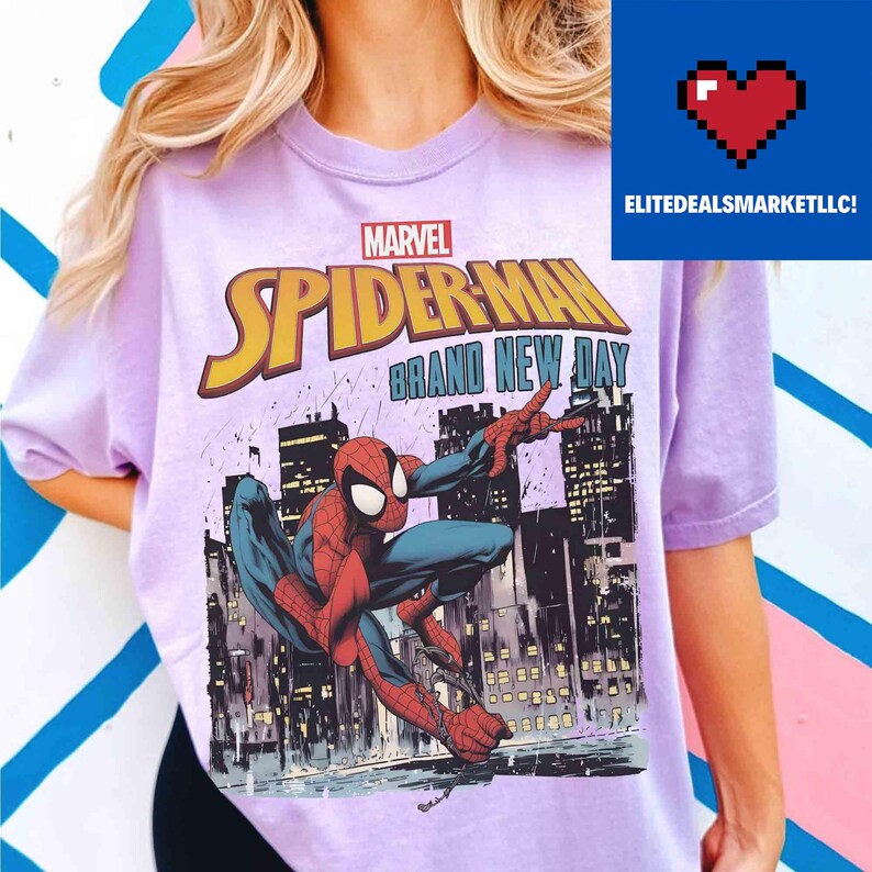 May include: A lilac t-shirt with a Spider-Man comic book illustration. The design features the text "MARVEL SPIDER-MAN BRAND NEW DAY" in yellow and red. The image depicts Spider-Man in action against a city backdrop.