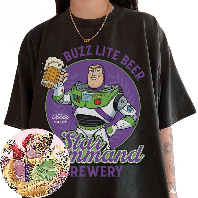 Może przedstawiać: Czarny t-shirt z grafiką Buzza Astrala trzymającego kufel piwa. Tekst głosi BUZZ LITE BEER, Star Command BREWERY oraz BEST Quality SINCE 1995. Okrągła wstawka przedstawia ilustrację trzech przytulających się postaci z animacji.