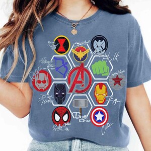 Pu&ograve; includere: T-shirt blu con un design di loghi e firme di supereroi. La maglietta include i loghi di Black Widow, Captain Marvel, Hulk, Iron Man, Spider-Man e Captain America. Il logo centrale &egrave; il simbolo degli Avengers.