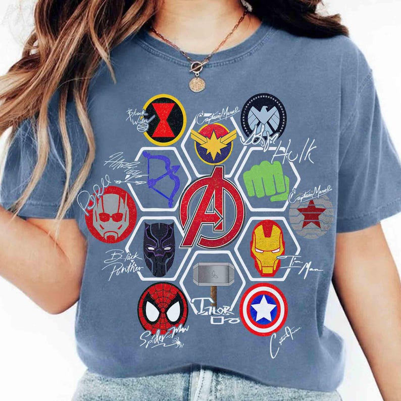 Pu&ograve; includere: T-shirt blu con un design di loghi e firme di supereroi. La maglietta include i loghi di Black Widow, Captain Marvel, Hulk, Iron Man, Spider-Man e Captain America. Il logo centrale &egrave; il simbolo degli Avengers.