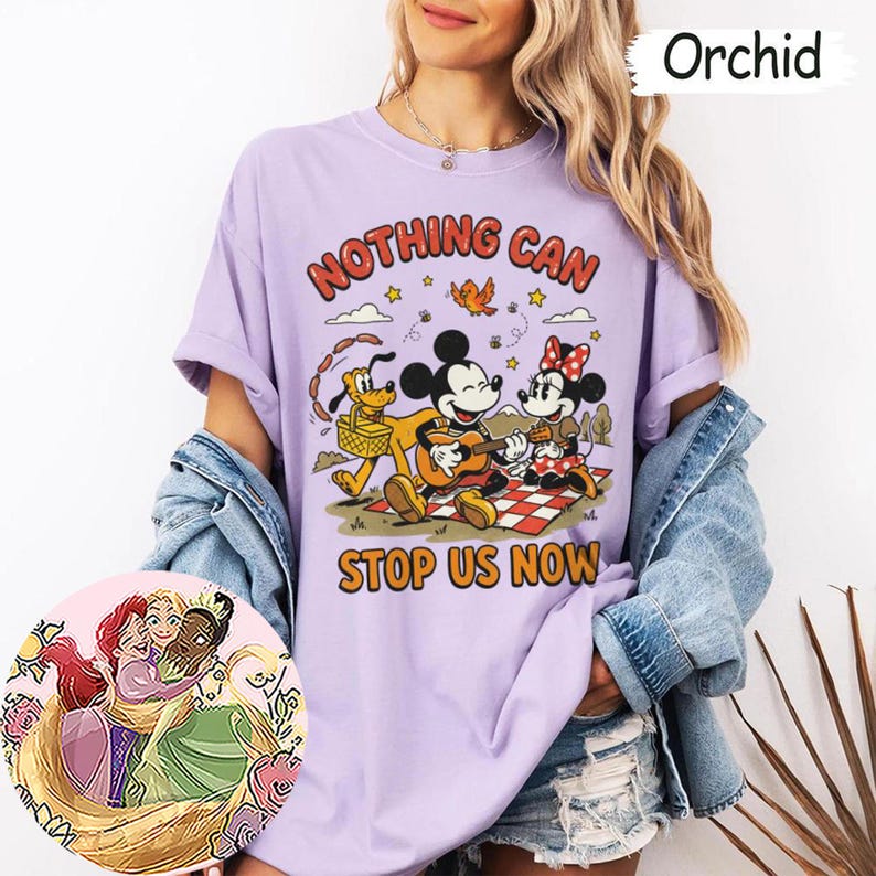 May include: An orchid-colored t-shirt featuring a graphic of Mickey Mouse playing a guitar, Minnie Mouse, and Pluto on a picnic. The text reads NOTHING CAN STOP US NOW. A circular inset shows an illustration of three animated characters embracing.