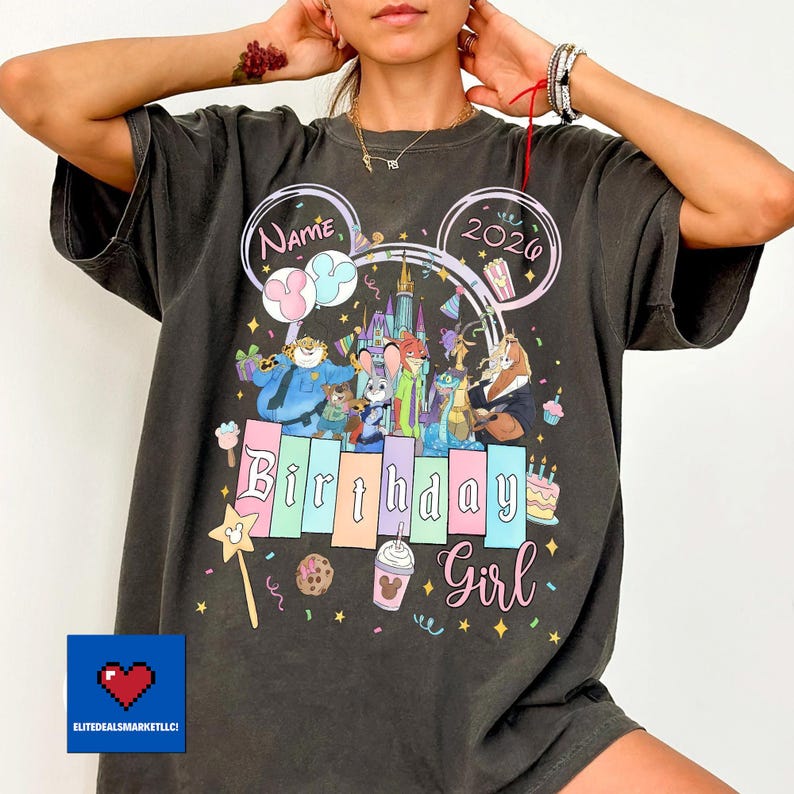 May include: Dark gray t-shirt with a colorful Disney-themed birthday design. The design includes the text "Name" and "2020" in Mickey Mouse ears, along with various Disney characters and the words "Birthday Girl".