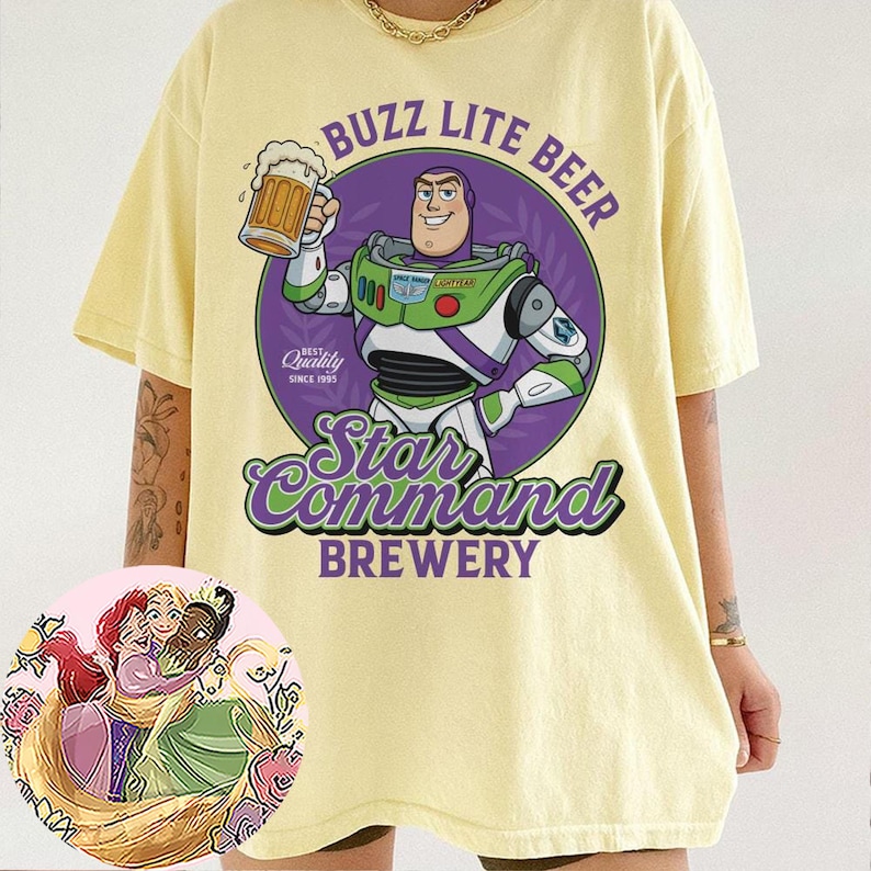 Może przedstawiać: Jasnoż&oacute;łty t-shirt z kr&oacute;tkim rękawem z grafiką przedstawiającą postać strażnika kosmicznego trzymającego kufel piwa. Tekst głosi BUZZ LITE BEER, Star Command BREWERY oraz BEST Quality SINCE 1995. Okrągła wstawka przedstawia trzy animowane postacie.