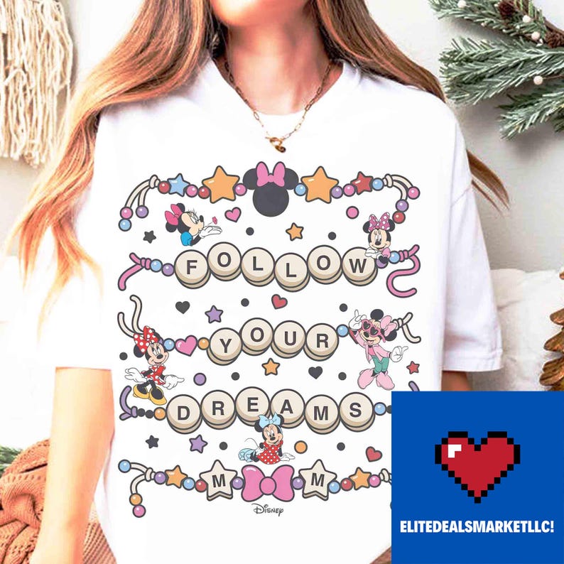 May include: White t-shirt featuring the text "FOLLOW YOUR DREAMS" with Minnie Mouse characters and decorative elements. The design includes stars, hearts, and bows. The Disney logo is at the bottom.