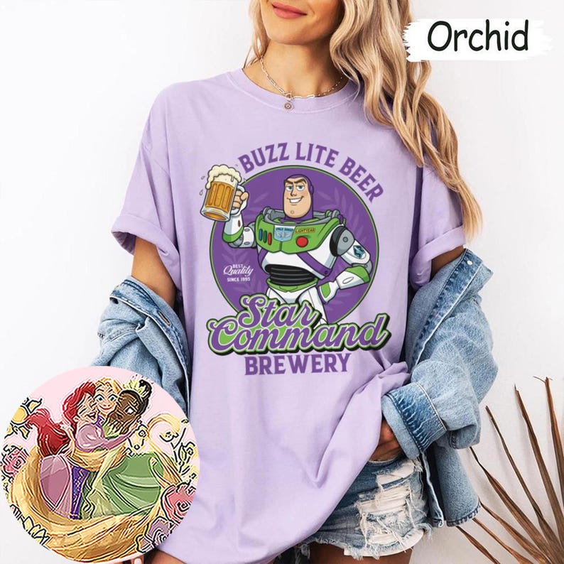 Może przedstawiać: Koszulka w kolorze orchidei z grafiką przedstawiającą Buzza Astrala trzymającego kufel piwa z napisem BUZZ LITE BEER Star Command BREWERY. Okrągła wstawka przedstawia ilustrację Ariel, Roszpunki i Tiany przytulających się do siebie.