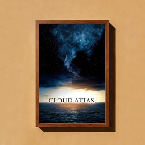 Op de afbeelding: Een ingelijste rechthoekige print met een donkerblauwe nachtelijke hemel vol sterren boven een kalme oceaanhorizon bij zonsondergang. De tekst CLOUD ATLAS staat in een zwart schreeflettertype in het midden binnen de houten lijst.