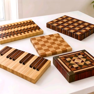 May include: A collection of handcrafted wooden cutting boards with various designs. The boards feature patterns like a checkerboard, a piano keyboard, and geometric shapes, showcasing a mix of light and dark wood tones. The boards are displayed on a white surface.