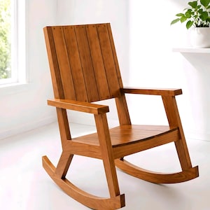 May include: A wooden rocking chair with a natural finish. The chair features a slatted backrest, armrests, and curved rockers. The chair is made of wood and has a warm, inviting appearance. The chair is designed for relaxation and comfort.