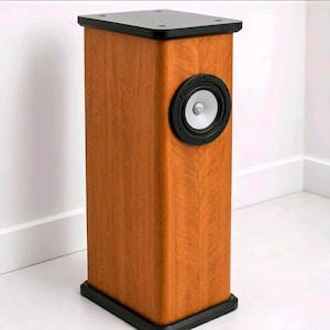 Peut inclure: Une enceinte colonne rectangulaire haute avec une finition en grain de bois brun clair. Elle présente une plaque de base noire en haut et en bas, ainsi qu'un haut-parleur circulaire unique avec un cône argenté centré sur la façade.