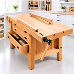 May include: A light-colored wooden workbench featuring a thick rectangular top, a front-mounted metal vise with a wooden handle, and two drawers with black pulls. One drawer is partially open, revealing a hand plane stored inside the compartment.