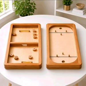 May include: Two wooden tabletop games with light wood surfaces and brown wooden frames. One game has a divided playing area with wooden pucks and rubber bands. The other has a curved end and pegs.