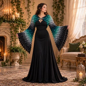 May include: A floor-length black dress featuring a fitted bodice and a long, flowing skirt. The garment includes a decorative bolero-style overlay with wide, flared sleeves, showcasing a gradient pattern of teal, grey, and black scale-like textures.