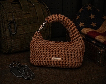 Bolso de mano hecho a mano de color marrón camello, tejido a crochet con asa superior y herrajes dorados.