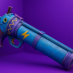Puede incluir: Una pistola de juguete azul y morada con detalles amarillos. La pistola de juguete tiene una textura de madera y un diseño de rayo. La pistola de juguete está sobre un fondo morado.