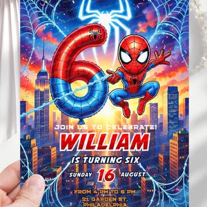 Op de afbeelding: Een kleurrijke uitnodiging met Spider-Man, een rood-blauwe ballon met het cijfer zes en een stadsgezicht op de achtergrond. De tekst luidt: "Doe met ons mee om te vieren! William wordt zes" met evenementdetails. Het ontwerp bevat spinnenwebben en een spinnenlogo.