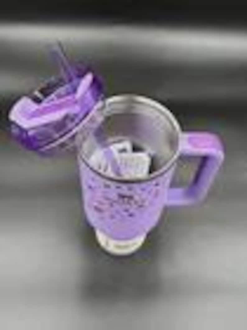 Puede incluir: Una m&aacute;quina el&eacute;ctrica para hacer sopa, de color morado y plateado, con un asa y una tapa transparente. La tapa est&aacute; abierta, revelando el interior. La m&aacute;quina est&aacute; sobre una superficie de acero inoxidable.
