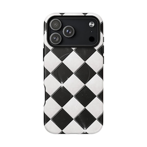May include: A black and white checkered phone case with a camera module featuring three lenses. The case has a glossy finish and a circular indentation on the back. The design is a repeating pattern of black and white squares.