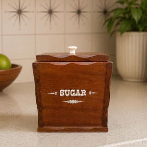 Açucareiro vintage de madeira, estilo meados do século XX, com tampa e puxador de cerâmica.