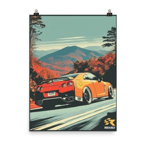 Pode incluir: Um cartaz com um carro desportivo laranja numa estrada com uma paisagem montanhosa. O carro tem um spoiler e rodas pretas. O cartaz inclui o texto "ROAD & RALLY" e um logótipo no canto inferior direito.