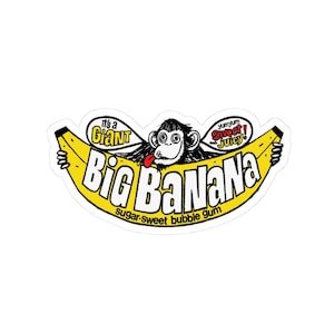 May include: A sticker featuring a yellow banana with the text "Big Banana" in a bold font. A cartoon monkey with its tongue out is in the center. The text "It's a Giant" and "Yumyum Sweet! Juicy" are also included.