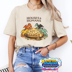 Peut inclure: T-shirt beige avec l'inscription "HOUSES & HUMANS" et un dessin de dragons autour d'une table. Les dragons sont orange, vert et jaune. Comprend un graphique de téléchargement numérique.