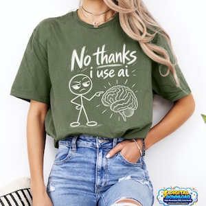 Może przedstawiać: Oliwkowozielony t-shirt z białą grafiką przedstawiającą ludzika z kresek wskazującego na ilustrację mózgu. Tekst nad grafiką brzmi "No thanks i use ai" i jest napisany białą czcionką w stylu odręcznego rysunku.