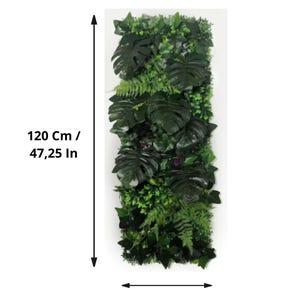 May include: Vertical artificial plant wall, 47.25 inches tall and 15.75 inches wide, featuring a variety of green foliage, including large, dark green monstera leaves and smaller ferns. The wall is designed to mimic a natural, lush environment.