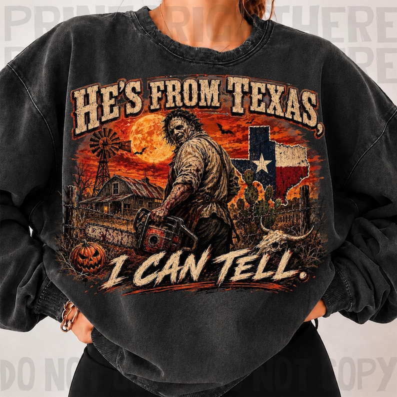 Puede incluir: Una sudadera gris carb&oacute;n de cuello redondo con un estampado gr&aacute;fico de un personaje de pel&iacute;cula de terror sosteniendo una motosierra. El dise&ntilde;o incluye un granero, un molino, una calabaza, la bandera de Texas y el texto HE'S FROM TEXAS, I CAN TELL.