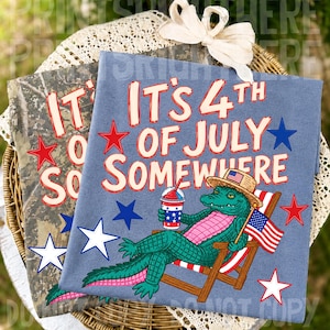 May include: Two t-shirts with patriotic designs. One is blue with the text "It's 4th of July Somewhere" and a cartoon alligator in a beach chair. The other is camouflage with the text "It's 4th of July Somewhere".