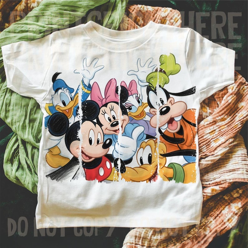 May include: White t-shirt featuring a colorful graphic of Disney characters including Mickey Mouse, Minnie Mouse, Donald Duck, Daisy Duck, and Goofy. The design has a distressed, vintage look.