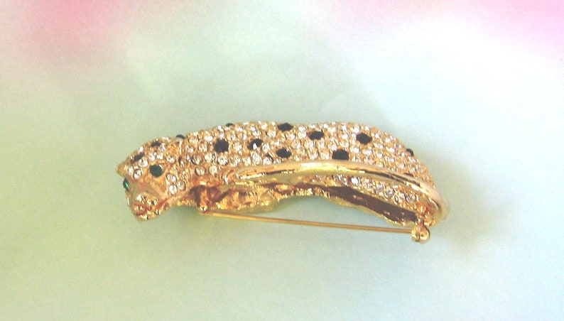 AVON Kenneth Lane Panther Brooch Pin KJL AVON Book Piece Three dementional with green eyes black stones and lots of pave clear crystals