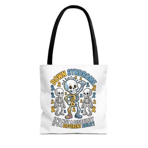 May include: White tote bag with black handles featuring a cartoon skeleton design. The design includes the words "Down Syndrome" and "It's Not a Disability It's a Different Ability" with blue and yellow ribbons.