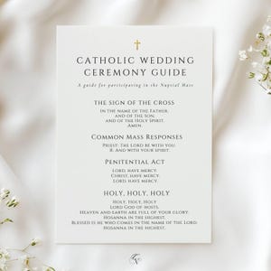 Puede incluir: Una tarjeta blanca con el texto "Catholic Wedding Ceremony Guide" y una cruz dorada en la parte superior. La guía incluye texto para la Señal de la Cruz, las respuestas comunes de la misa y el acto penitencial.